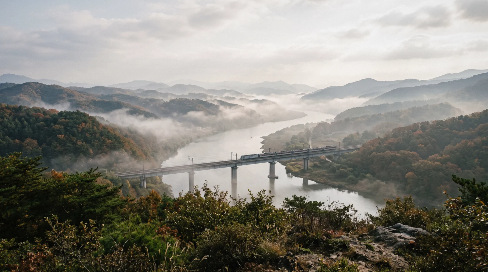 Morning mist over a river valley outside Seoul with wooded hills, South Korea