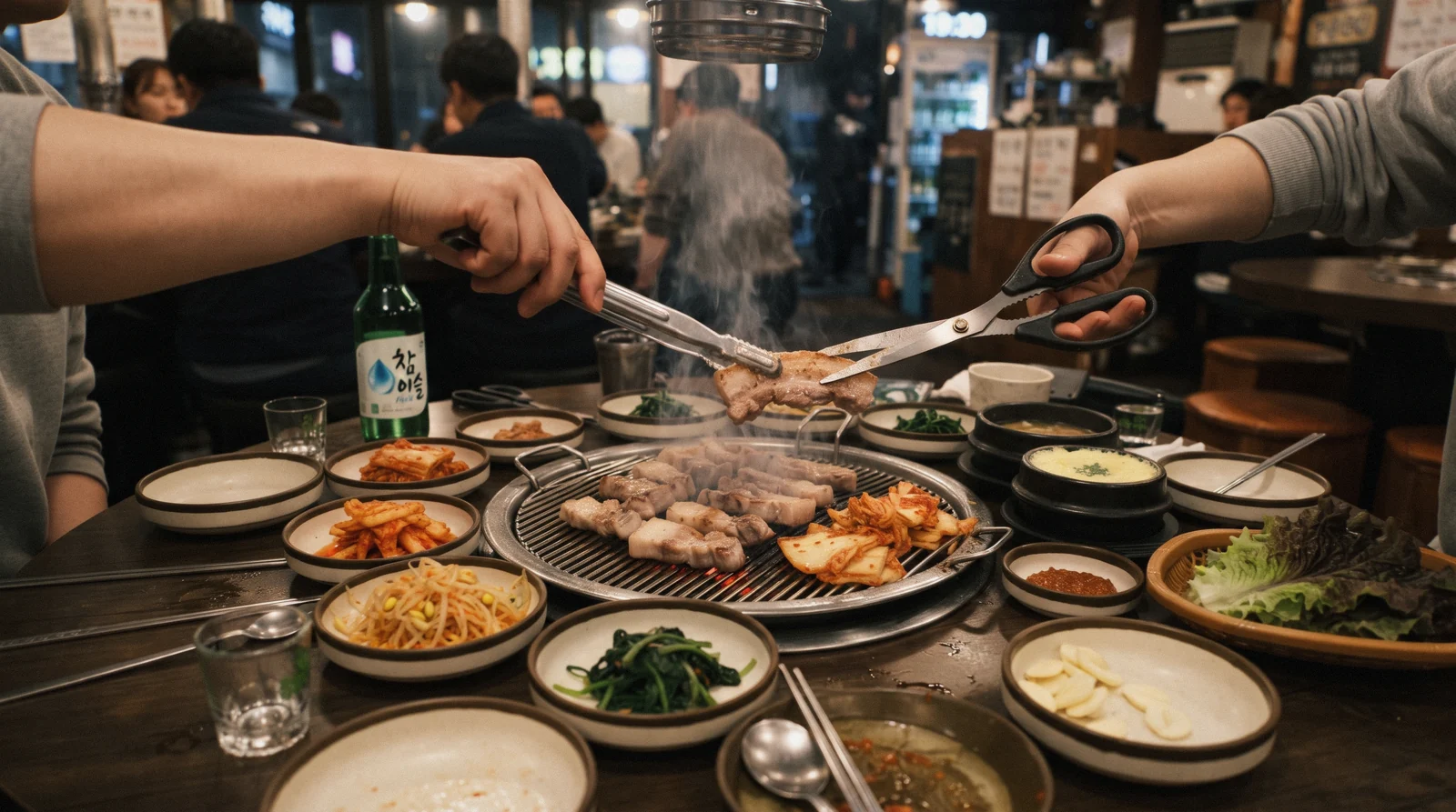Hands turning pork belly on a Korean BBQ table grill in Seoul, South Korea